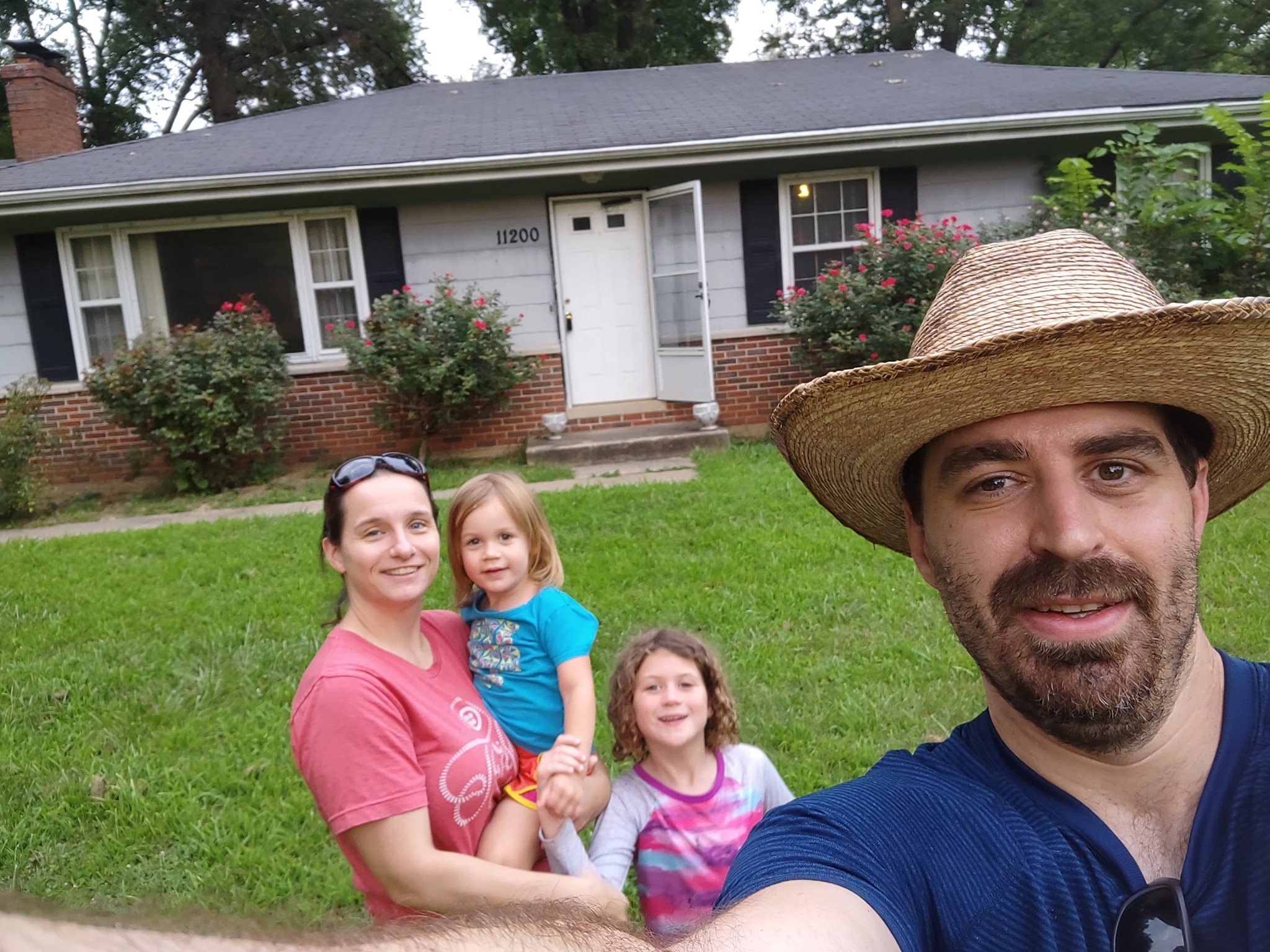 Family standing in front of house